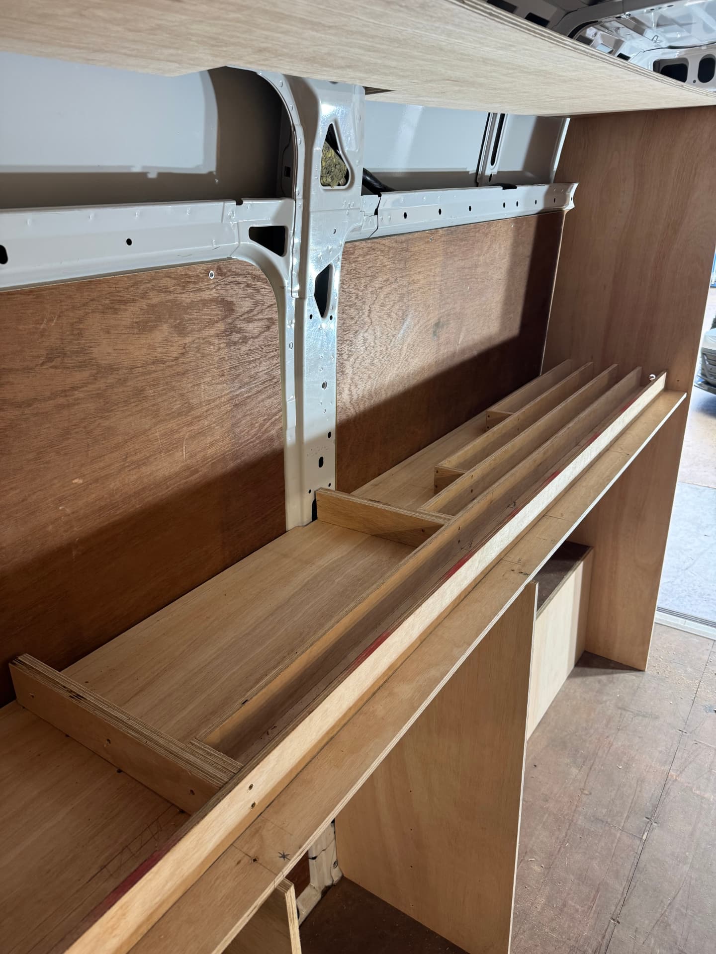 Bespoke plywood van racking and shelving being fitted in a commercial van load area